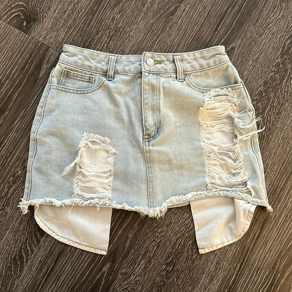 Light blue distressed short jean skirt.